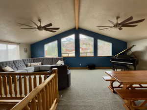 Living area with vaulted ceiling, carpet flooring, and ceiling fan