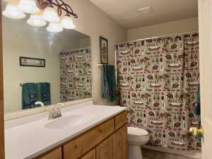 Full bath with vanity, an inviting chandelier, toilet, tile patterned flooring, and visible vents