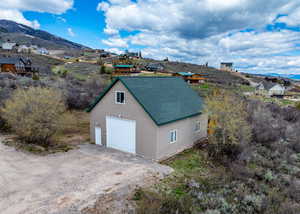 Garage featuring dirt driveway, a mountain view, and a garage