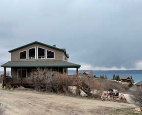 View of home featuring a porch and roof with shingles