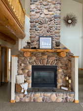 Room details featuring baseboards, a stone fireplace, and carpet