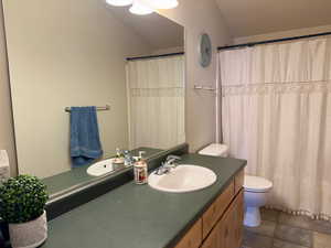 Bathroom with vanity, a shower with shower curtain, and toilet