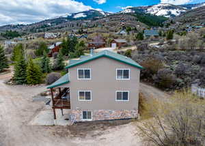 View of side of property with dirt driveway and a mountain view