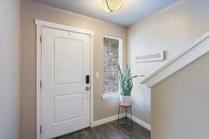 Entrance foyer with baseboards and dark wood finished floors