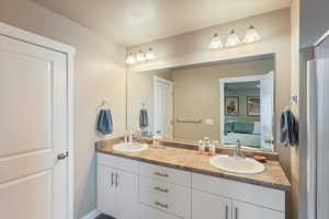 Ensuite bathroom with ensuite bathroom, a sink, double vanity, and a ceiling fan