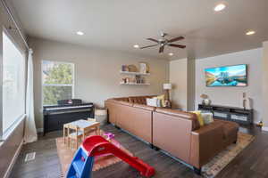 Living room featuring a ceiling fan, baseboards, dark wood-style flooring, visible vents, and recessed lighting
