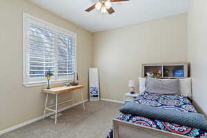 Carpeted bedroom with visible vents, a ceiling fan, and baseboards
