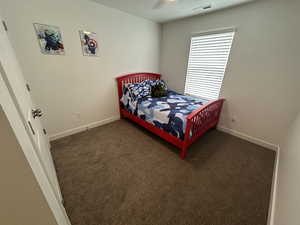 Carpeted bedroom with baseboards and visible vents