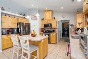 Kitchen featuring backsplash, stainless steel appliances, light countertops, and light tile patterned floors