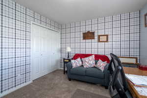 Carpeted living room with wallpapered walls