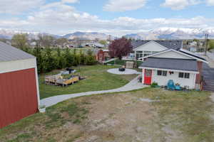 View of yard featuring a storage unit, an outdoor structure, a mountain view, and an outdoor fire pit