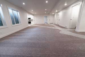 Interior space featuring light colored carpet, baseboards, and recessed lighting