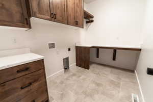 Clothes washing area with visible vents, hookup for an electric dryer, baseboards, cabinet space, and washer hookup