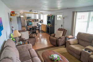 Living area with light wood finished floors and a textured ceiling