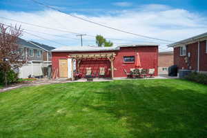 Back of house featuring a lawn, fence, a patio area, and cooling unit