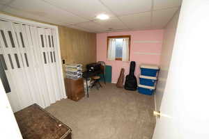 Carpeted office space with baseboards and a paneled ceiling