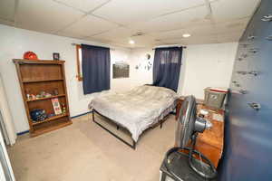 Carpeted bedroom with baseboards, visible vents, a drop ceiling, and recessed lighting