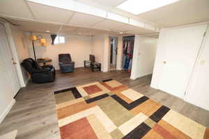 Sitting room with baseboards, wood finished floors, and a drop ceiling