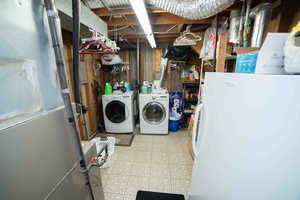 Clothes washing area featuring tile patterned floors, laundry area, and washer and clothes dryer