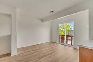 Empty room featuring baseboards, visible vents, and light wood finished floors