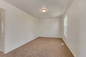 Unfurnished room with baseboards and light colored carpet