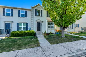 View of property with a front lawn and stucco siding