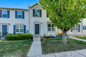 Townhome / multi-family property featuring stucco siding and a front lawn