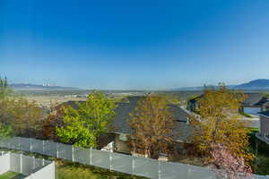 Property view of water with a fenced backyard and a mountain view