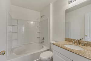 Bathroom featuring shower / bath combination, toilet, and vanity