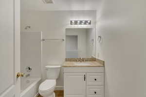 Full bathroom featuring visible vents, vanity, washtub / shower combination, and toilet