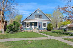 Bungalow-style house featuring a porch, board and batten siding, and a front yard