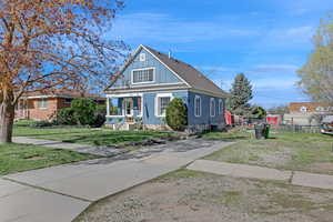 Bungalow featuring board and batten siding, fence, covered porch, and a front yard