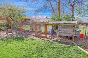 View of yard featuring an outdoor structure, a mountain view, fence, and exterior structure
