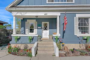 Property entrance featuring fence and covered porch