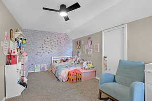 Bedroom featuring lofted ceiling, a ceiling fan, and carpet floors