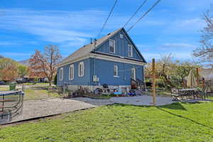 Rear view of house with fence, a lawn, a gate, and a patio area