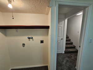 2nd bedroom in basement could be a laundry but curently a bedroom with a closet /Washroom with a textured ceiling, hookup for an electric dryer, carpet floors, baseboards, and washer hookup