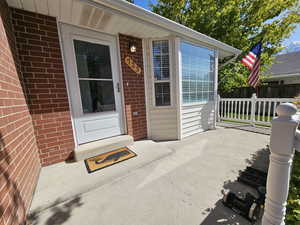 Entrance to property featuring brick siding and fence