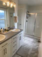 Bathroom featuring a stall shower and a sink