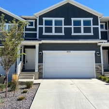 View of front of house featuring driveway, stone siding, board and batten siding, and a garage