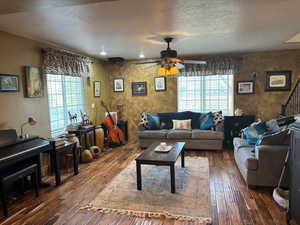 Living area with ceiling fan, hardwood / wood-style floors, and a textured ceiling