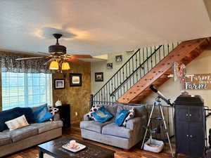 Living area featuring hardwood / wood-style flooring, a textured ceiling, stairs, and ceiling fan