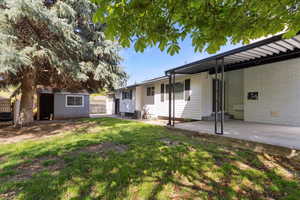 View of yard with fence, an outdoor structure, cooling unit, and a patio