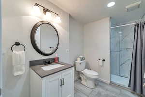 Full bath featuring baseboards, toilet, vanity, and a shower with curtain