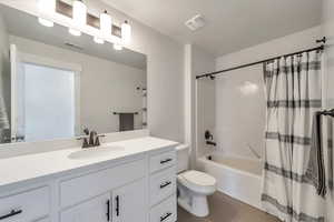 Bathroom with shower / bath combo with shower curtain, toilet, tile patterned floors, and visible vents