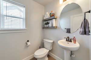 Half bath featuring toilet and baseboards