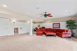 Carpeted living area featuring visible vents, a ceiling fan, baseboards, and recessed lighting