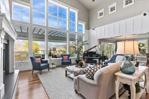 Living area featuring wood-type flooring, plenty of natural light, and a towering ceiling