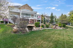 Rear view of property with a lawn, stairs, and a pergola