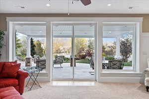 Doorway to outside featuring a ceiling fan, visible vents, recessed lighting, and light colored carpet